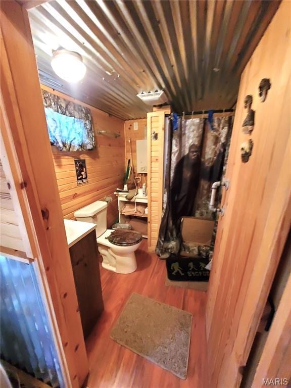 303 Arrowhead Trl, Hermann, MO 65041 - bathroom featuring toilet, wood finished floors, vanity, and wooden walls