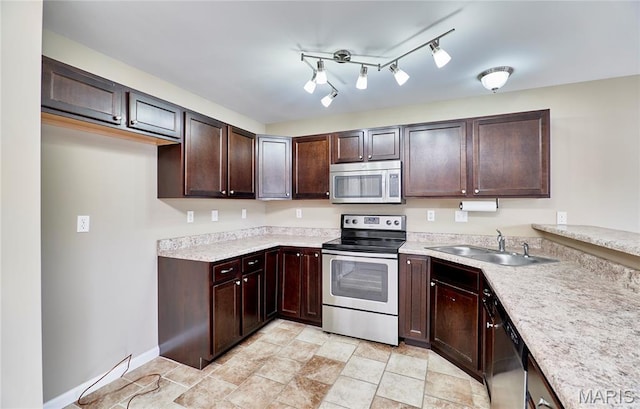 628 Meadowgreen Dr, Troy, MO 63379 - kitchen featuring appliances with stainless steel finishes, light countertops, dark brown cabinets, and light stone finish flooring