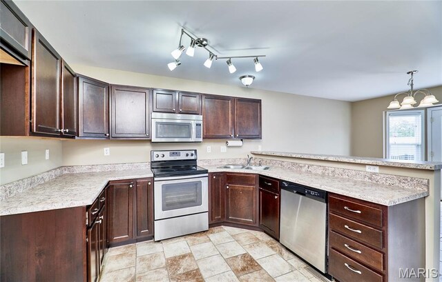 628 Meadowgreen Dr, Troy, MO 63379 - kitchen with stainless steel appliances, a peninsula, light countertops, a chandelier, and dark brown cabinets