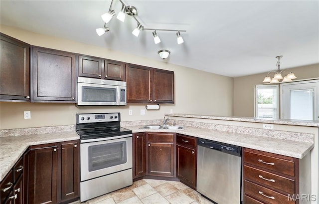 628 Meadowgreen Dr, Troy, MO 63379 - kitchen featuring appliances with stainless steel finishes, a peninsula, dark brown cabinets, a chandelier, and hanging light fixtures