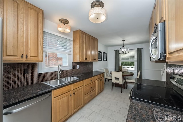 3644 Cinnamon Tree Ln, Oakville, MO 63129 - kitchen with stainless steel appliances, decorative backsplash, a chandelier, light tile patterned floors, and dark stone counters