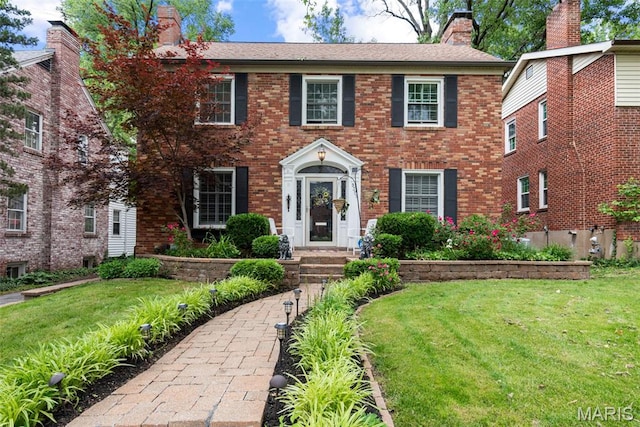 9351 White Ave, Brentwood, MO 63144 - colonial-style house featuring a front yard, brick siding, and a chimney