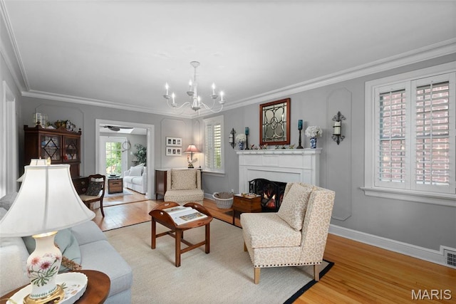 9351 White Ave, Brentwood, MO 63144 - living area featuring light wood-type flooring, a chandelier, ornamental molding, a warm lit fireplace, and baseboards