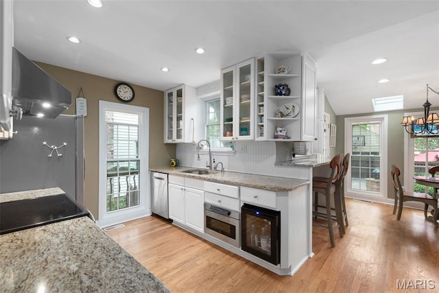 9351 White Ave, Brentwood, MO 63144 - kitchen with a sink, dishwasher, wall chimney range hood, white cabinetry, and open shelves