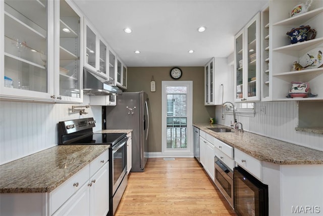 9351 White Ave, Brentwood, MO 63144 - kitchen with appliances with stainless steel finishes, a sink, under cabinet range hood, light wood-style flooring, and white cabinets