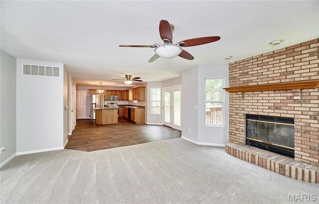 1583 Clarys Grv, Ofallon, IL 62269 - unfurnished living room with dark carpet, baseboards, a brick fireplace, a ceiling fan, and a textured ceiling