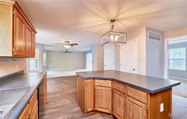 1583 Clarys Grv, Ofallon, IL 62269 - kitchen with dark countertops, stainless steel dishwasher, a chandelier, a kitchen island, and dark wood-type flooring