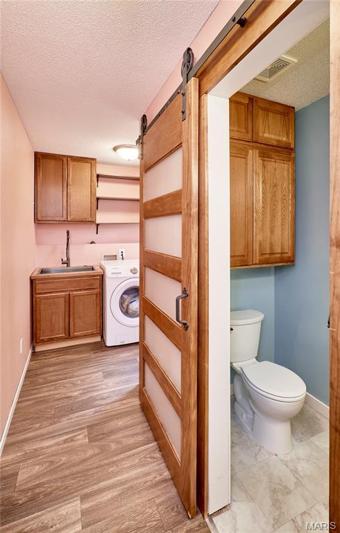 1583 Clarys Grv, Ofallon, IL 62269 - bathroom featuring washer / dryer, a textured ceiling, toilet, baseboards, and vanity