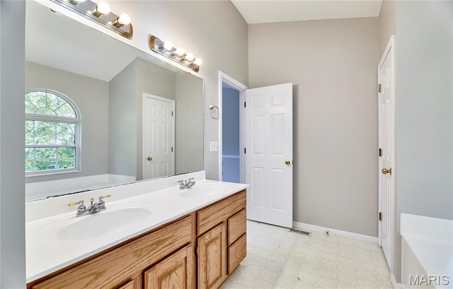 1583 Clarys Grv, Ofallon, IL 62269 - full bathroom featuring double vanity, a tub to relax in, tile patterned floors, and baseboards