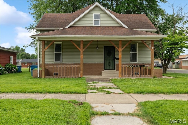 330 Elliott Ave, Chaffee, MO 63740 - view of front of property with covered porch, a shingled roof, a front lawn, and brick siding