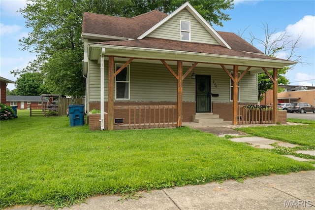 330 Elliott Ave, Chaffee, MO 63740 - view of front of property featuring covered porch, a shingled roof, a front yard, and brick siding