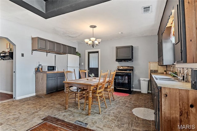 330 Elliott Ave, Chaffee, MO 63740 - dining area with baseboards, arched walkways, and a chandelier