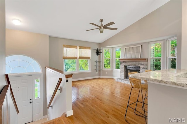 612 Hill Dr, Eureka, MO 63025 - foyer with a ceiling fan, light wood-style floors, a fireplace, healthy amount of natural light, and high vaulted ceiling