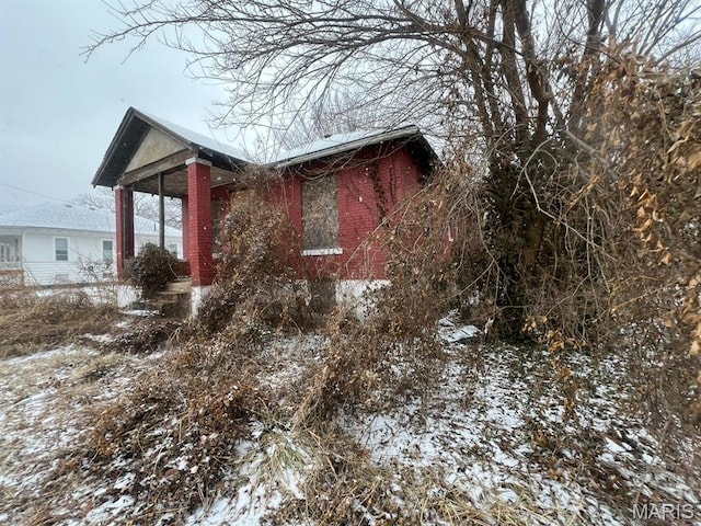 653 N 37th St E, St Louis, IL 62205 - view of snowy exterior featuring brick siding