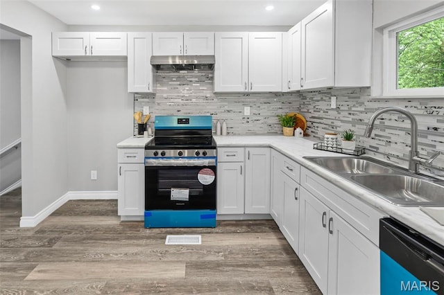 2012 Maple Tree Ln, Cahokia, IL 62206 - kitchen with electric range, dishwashing machine, under cabinet range hood, a sink, and white cabinetry