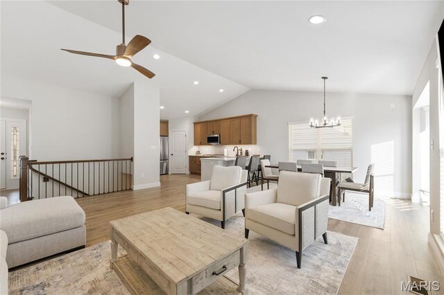 7405 Shadow Point Dr, Saint Louis, MO 63129 - living room featuring ceiling fan, light wood-style floors, a chandelier, baseboards, and high vaulted ceiling