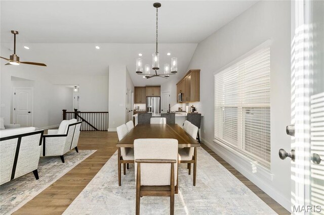 7405 Shadow Point Dr, Saint Louis, MO 63129 - dining area with vaulted ceiling, wood finished floors, a chandelier, ceiling fan, and baseboards