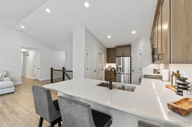 7405 Shadow Point Dr, Saint Louis, MO 63129 - kitchen featuring stainless steel fridge with ice dispenser, lofted ceiling, a peninsula, a sink, and a breakfast bar