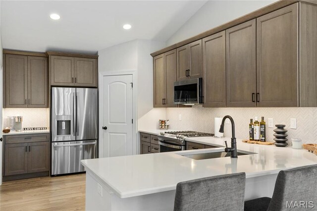7405 Shadow Point Dr, Saint Louis, MO 63129 - kitchen with appliances with stainless steel finishes, a peninsula, decorative backsplash, light countertops, and recessed lighting
