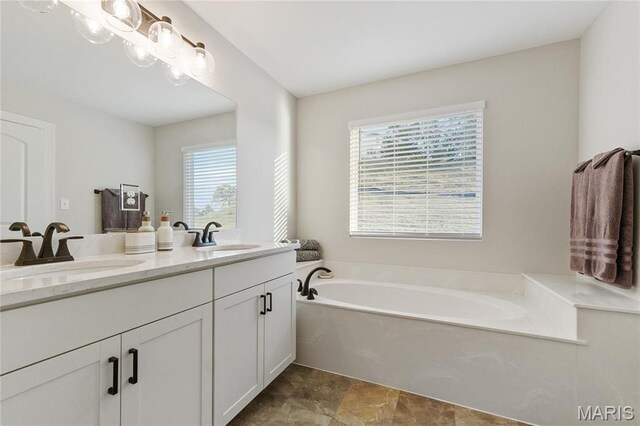 7405 Shadow Point Dr, Saint Louis, MO 63129 - bathroom featuring double vanity, a garden tub, and stone finish flooring