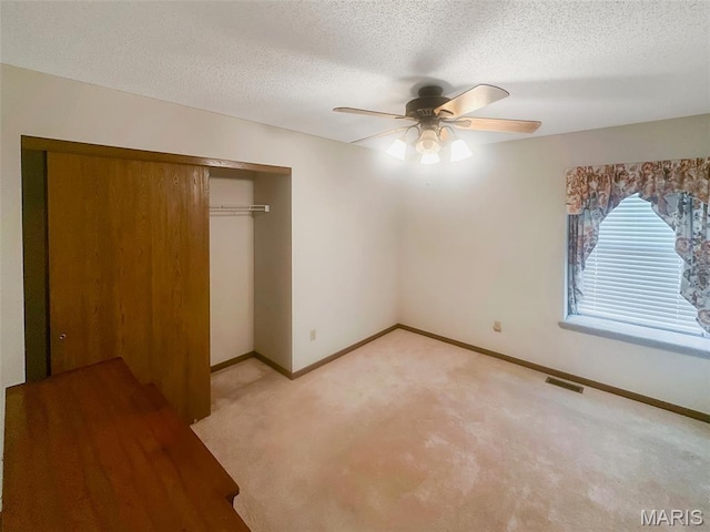 135 Misty View Ln, Saint Peters, MO 63376 - unfurnished bedroom featuring light colored carpet, a closet, baseboards, a textured ceiling, and ceiling fan