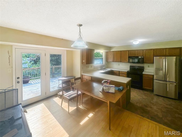 135 Misty View Ln, Saint Peters, MO 63376 - kitchen featuring black appliances, hardwood / wood-style flooring, light countertops, a textured ceiling, and pendant lighting