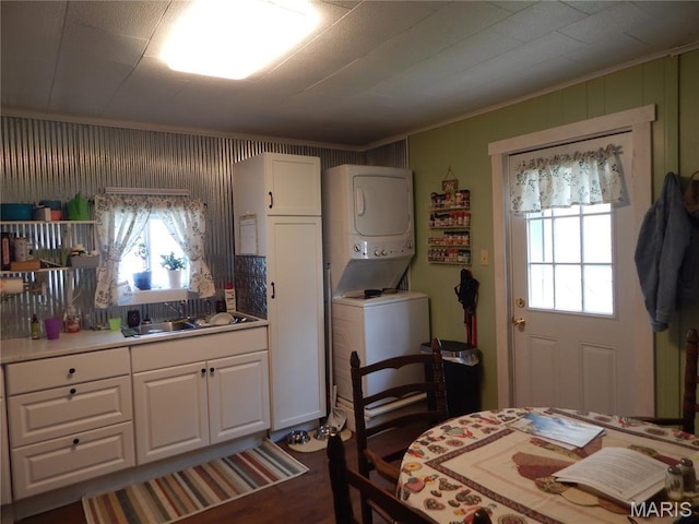1620 W Centennial Ave, Bowling Green, MO 63334 - kitchen featuring stacked washer and clothes dryer, white cabinetry, ornamental molding, and healthy amount of natural light