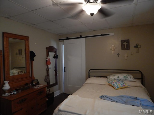 1620 W Centennial Ave, Bowling Green, MO 63334 - bedroom featuring a barn door, a paneled ceiling, dark wood finished floors, and a ceiling fan