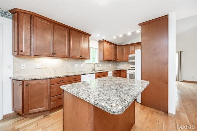 608 Andra Dr, Maryville, IL 62062 - kitchen with white appliances, a sink, light wood-style floors, tasteful backsplash, and brown cabinetry