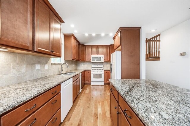 608 Andra Dr, Maryville, IL 62062 - kitchen with white appliances, a sink, light wood-style floors, brown cabinetry, and light stone counters