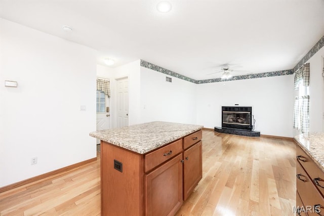 608 Andra Dr, Maryville, IL 62062 - kitchen featuring a ceiling fan, light wood finished floors, a center island, light stone countertops, and baseboards