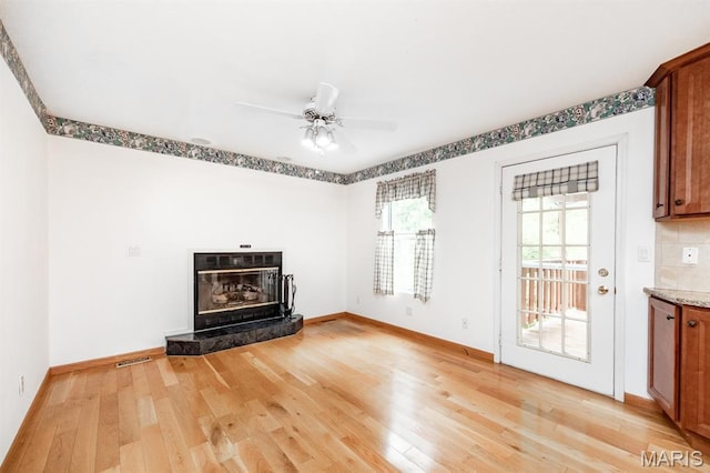 608 Andra Dr, Maryville, IL 62062 - unfurnished living room featuring light wood-style floors, baseboards, a ceiling fan, and a tile fireplace