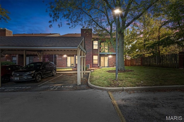 2339 Kratky Rd Unit A, Saint Louis, MO 63114 - view of front facade with a chimney, covered parking, brick siding, and a shingled roof
