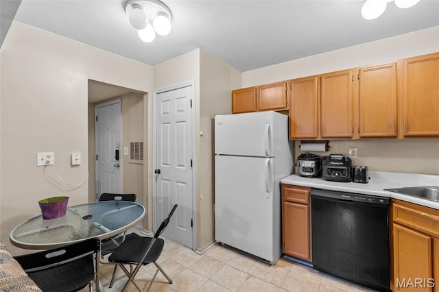 2339 Kratky Rd Unit A, Saint Louis, MO 63114 - kitchen featuring dishwasher, freestanding refrigerator, light countertops, light tile patterned floors, and a sink