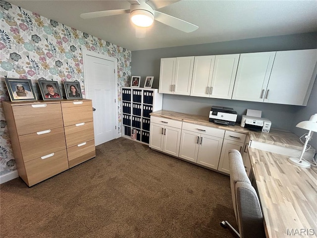 615 Jonathan Rd, Hannibal, MO 63401 - kitchen with wallpapered walls, ceiling fan, white cabinets, dark carpet, and wood counters