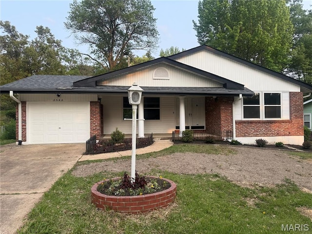 2542 Dukeland Dr, Ferguson Township, MO 63136 - view of front of home with driveway, a garage, brick siding, and covered porch