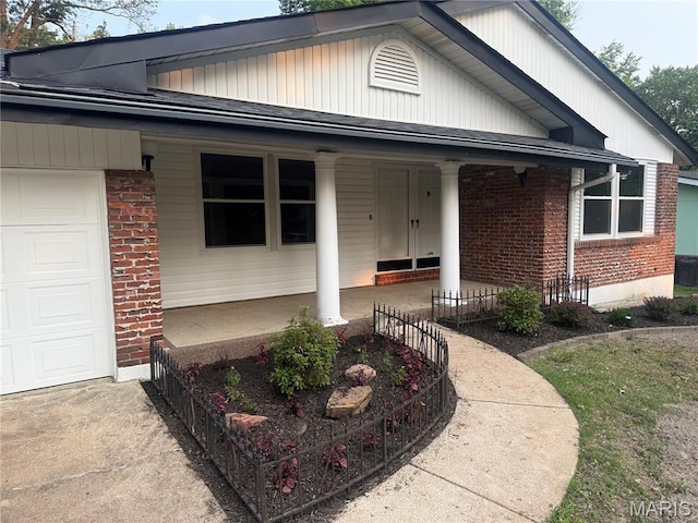 2542 Dukeland Dr, Ferguson Township, MO 63136 - view of front facade featuring covered porch, brick siding, driveway, and an attached garage
