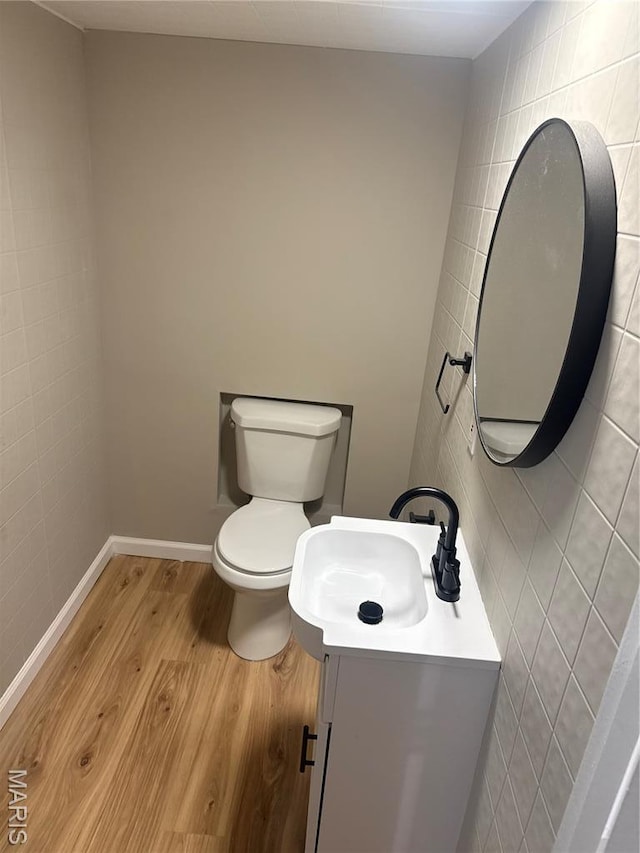 2542 Dukeland Dr, Ferguson Township, MO 63136 - half bathroom featuring vanity, wood finished floors, toilet, and tile walls