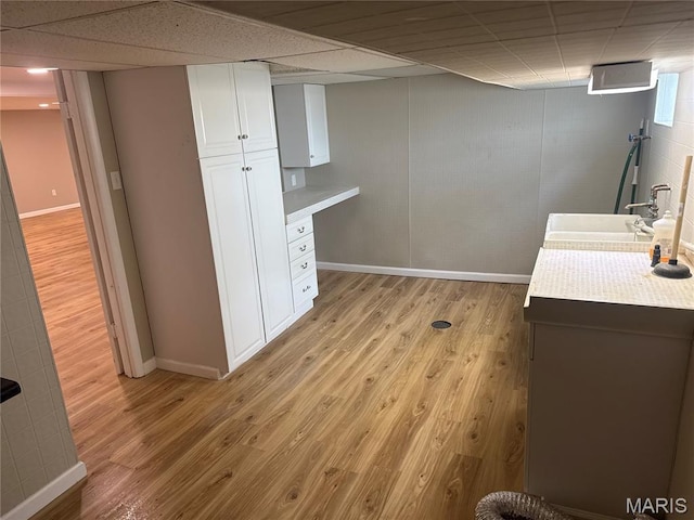2542 Dukeland Dr, Ferguson Township, MO 63136 - interior space with baseboards, light wood finished floors, a sink, and a paneled ceiling