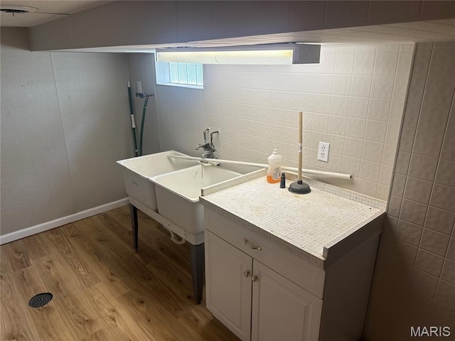 2542 Dukeland Dr, Ferguson Township, MO 63136 - bathroom featuring wood finished floors, tile walls, and a sink