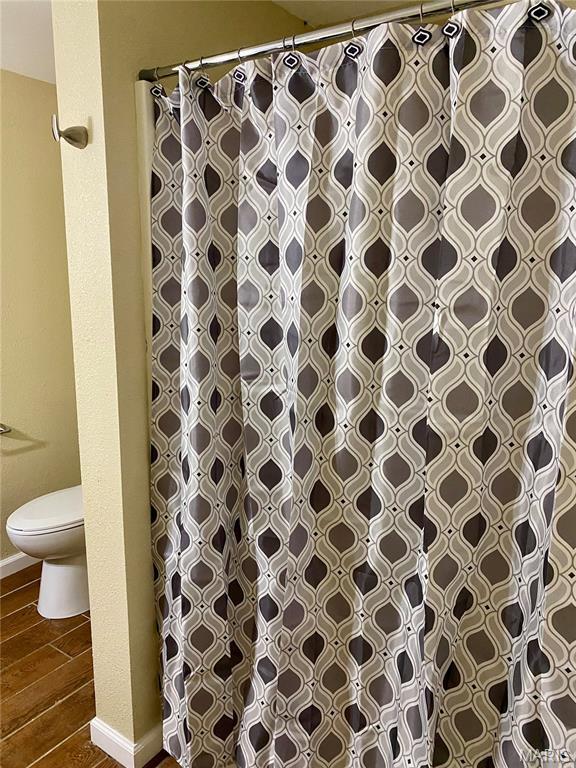 3936 State Highway 142, Doniphan, MO 63935 - bathroom with toilet, wood finished floors, a shower with curtain, and baseboards