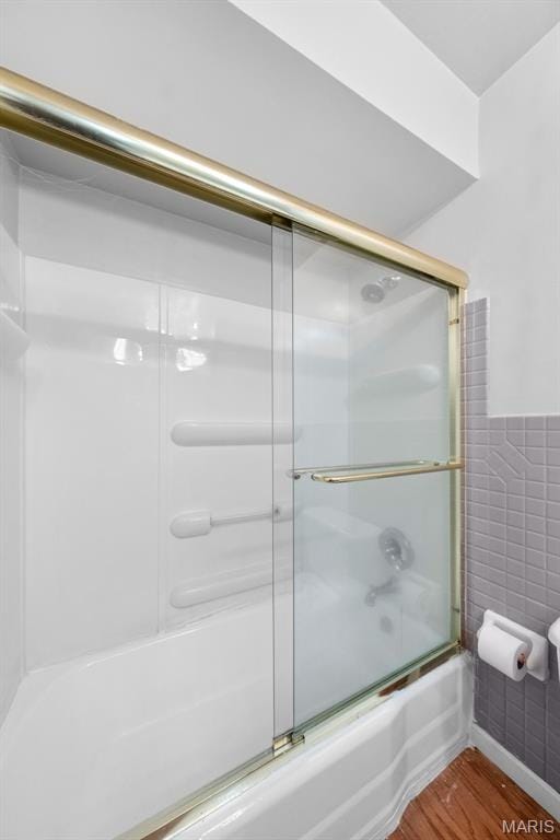 417 Concordia Ln, Saint Charles, MO 63301 - full bath with combined bath / shower with glass door, wood finished floors, tile walls, and wainscoting