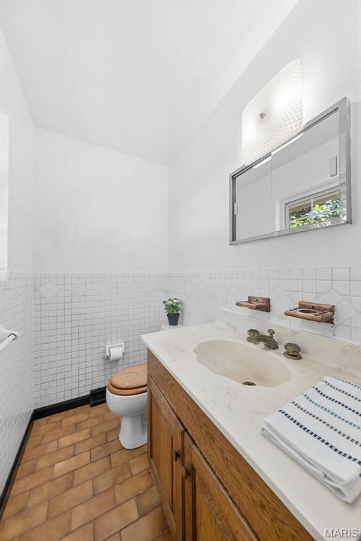 417 Concordia Ln, Saint Charles, MO 63301 - bathroom featuring tile walls, vanity, wainscoting, and tile patterned floors