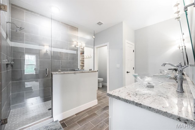 1821 Orr Ln, Ofallon, IL 62269 - full bathroom with double vanity, toilet, a stall shower, baseboards, and wood finish floors