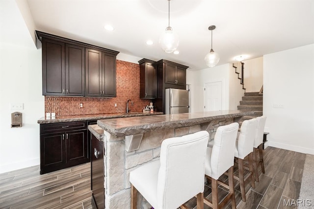 1821 Orr Ln, Ofallon, IL 62269 - kitchen featuring freestanding refrigerator, light wood-type flooring, decorative backsplash, a kitchen breakfast bar, and baseboards