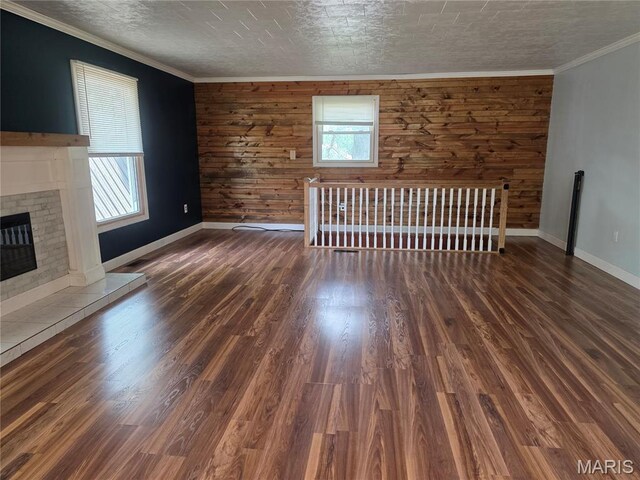 18835 Mary Jane Ln, Carlyle, IL 62231 - unfurnished living room with wood walls, baseboards, wood finished floors, a glass covered fireplace, and ornamental molding