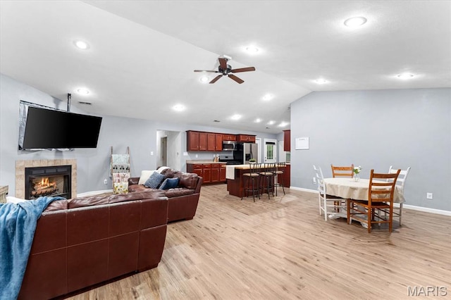 9138 Lynwood Ln, Fairview Heights, IL 62208 - living area featuring lofted ceiling, light wood-type flooring, a ceiling fan, baseboards, and a tile fireplace