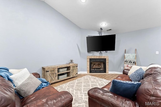 9138 Lynwood Ln, Fairview Heights, IL 62208 - living room with wood finished floors, vaulted ceiling, a tiled fireplace, and baseboards