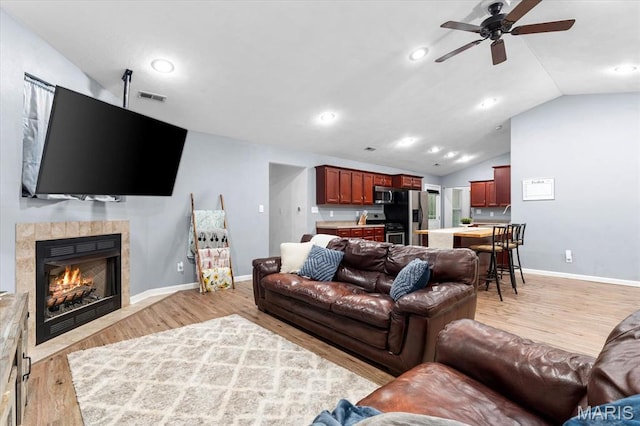 9138 Lynwood Ln, Fairview Heights, IL 62208 - living area featuring ceiling fan, vaulted ceiling, a fireplace, light wood-style flooring, and baseboards
