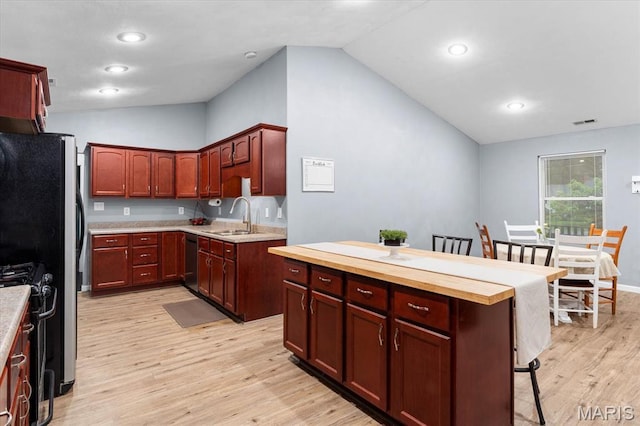 9138 Lynwood Ln, Fairview Heights, IL 62208 - kitchen with dishwashing machine, lofted ceiling, a sink, light wood-style floors, and gas range oven